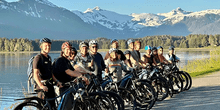 The Ultimate Guide to e-Bike Excursions in Alaska 2 Large group on e-bikes excursions in Alaska, posing in front of snowy mountains.