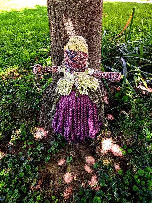 Leela the You-Do-You Voodooโข art doll for health and wellness takes a stand under a tree.