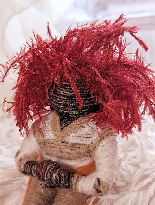 Side view of "Silma" that highlights the doll's darker complexion, red hair with its electric style, and detailed tracksuit.