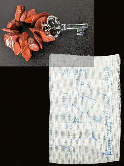 Red jasper keychain with a tiny silver key and a scrap of burlap with a sketch of an angry person and words of intention.