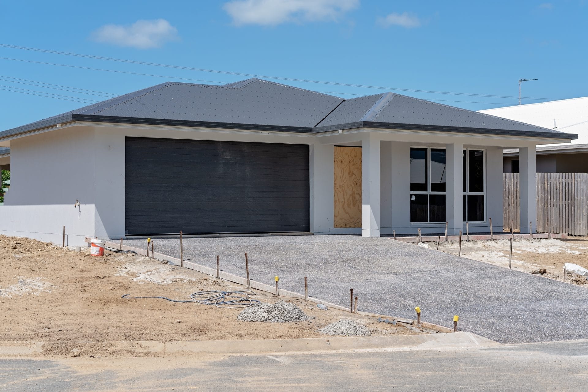 custom home construction Florida - Modern custom home construction in Florida with sleek design, large windows, and lush land