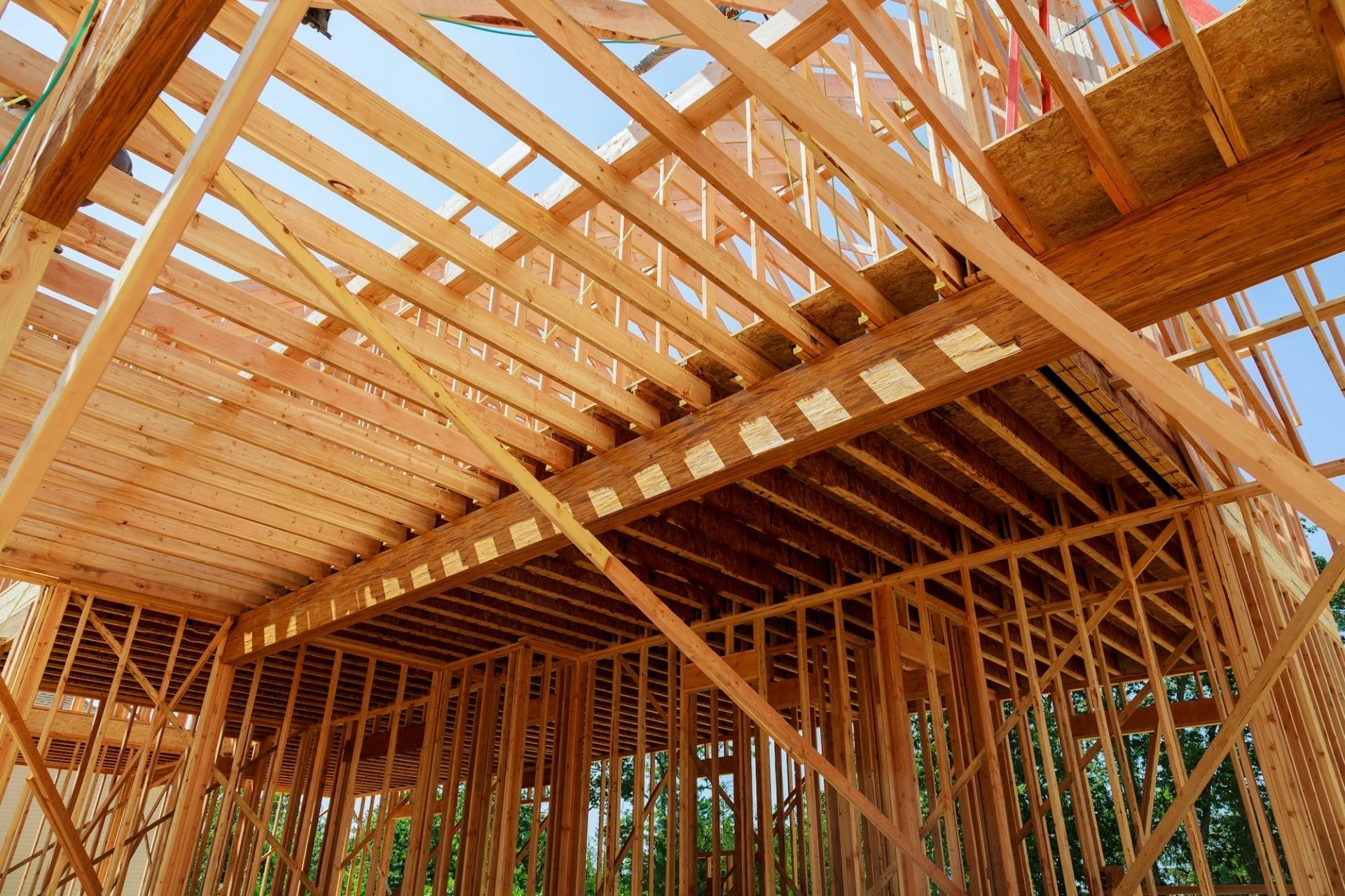 Wooden framework of a new residential house under construction, showcasing beams and supports in an open structure.