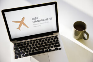 Image of laptop with airplane image and risk management sign.
