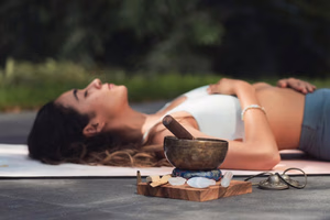 Pexels-Photo-8391652-8391652 Een vrouw oefent ontspanning met een klankschaal en kristallen in een buitenomgeving.