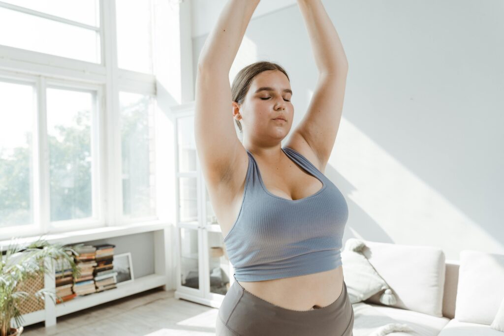Pexels-Photo-8846107-8846107 Een vrouw met een grote maat die zich thuis inzet voor body positivity en stretching voor een gezonde levensstijl.
