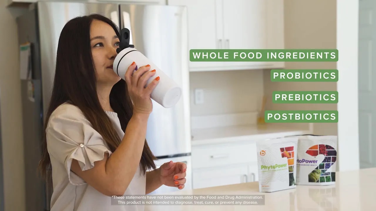 Boost Microbiome Gut Health With Lovebiome P84 &Amp; Protandim 2 Person drinking a supplement shake in a kitchen with product pouches on the counter and green callouts reading whole food ingredients, probiotics, prebiotics, postbiotics