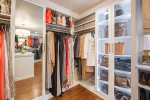 Enclosed closet cabinetry with glass Enclosed cabinetry in custom closet design.
