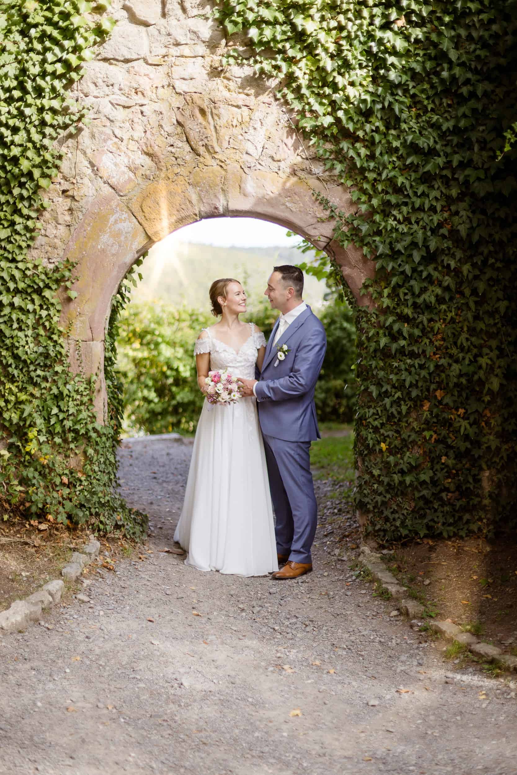 hochzeitsfotograf calw Brautpaar Lisa und Max bei ihrer Hochzeit in Nagold unter einem alten Torbogen.