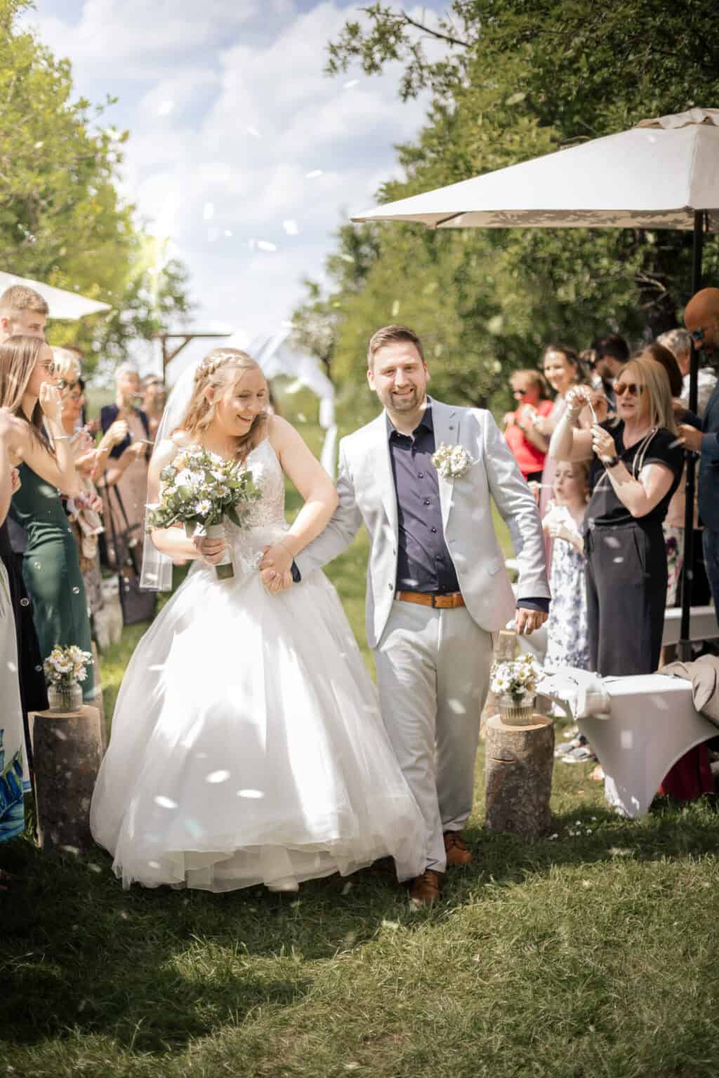 hochzeitsfotograf Pforzheim Hochzeitsfotograf Pforzheim Fröhliches Brautpaar bei einer Gartenhochzeit, umgeben von Freunden und Familie.