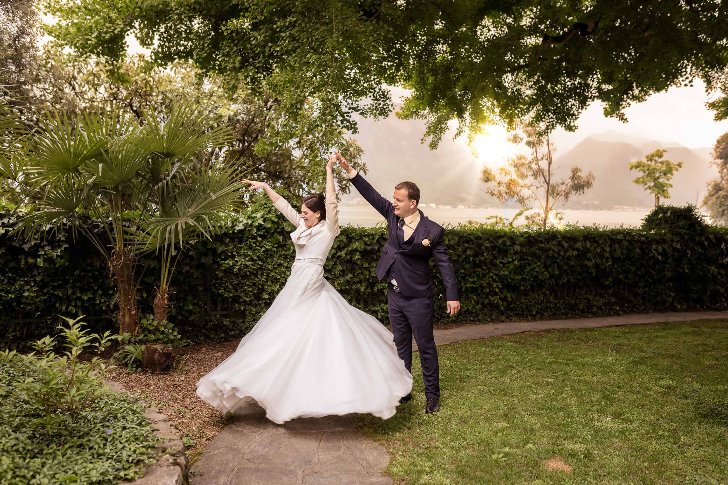 Brautpaar tanzt im Garten mit Blick auf Berge – emotionale Hochzeit am See