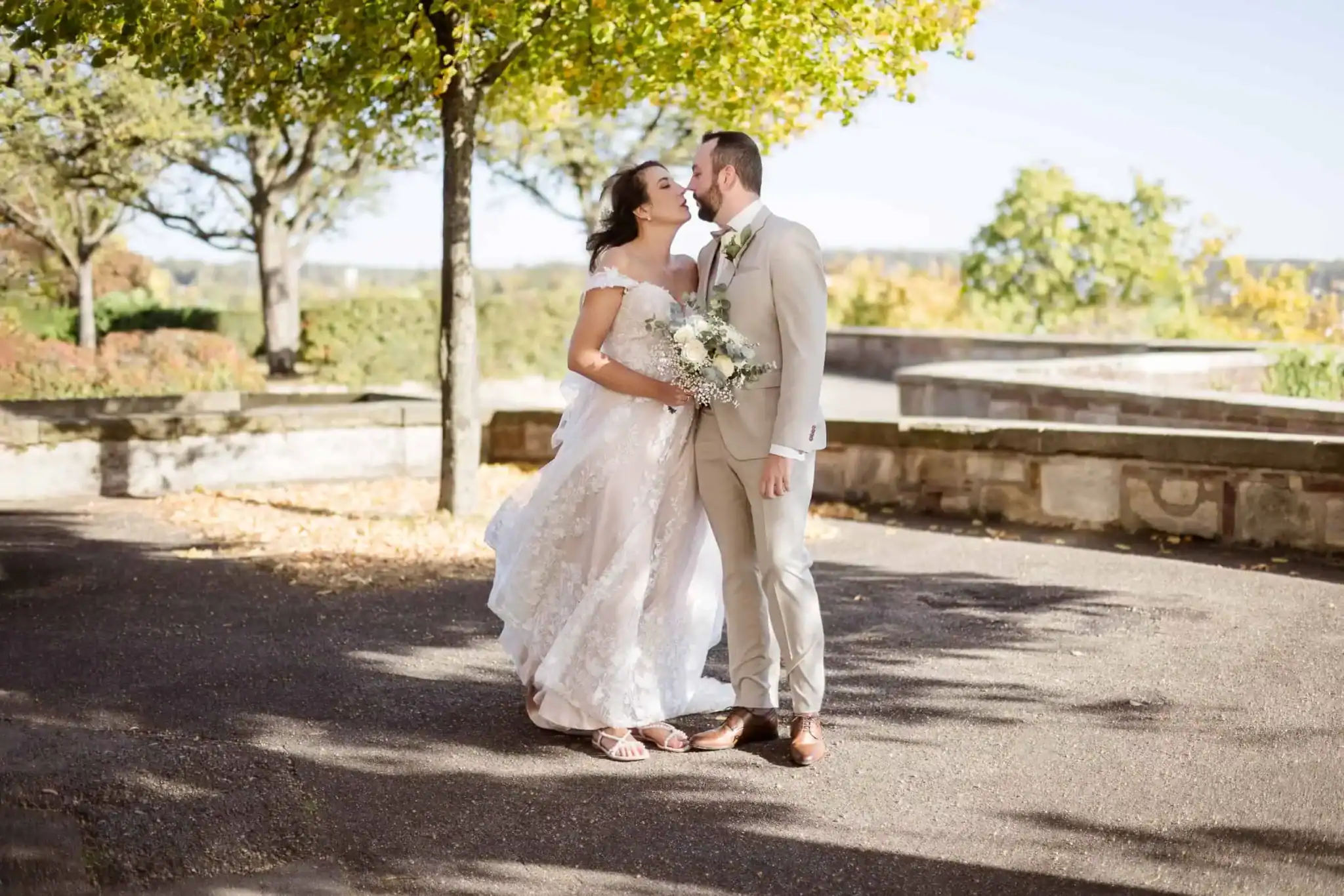 kleine Hochzeit mit Hochzeitsfotograf fĂĽr echte Momente Brautpaar kĂĽsst sich im herbstlichen Garten