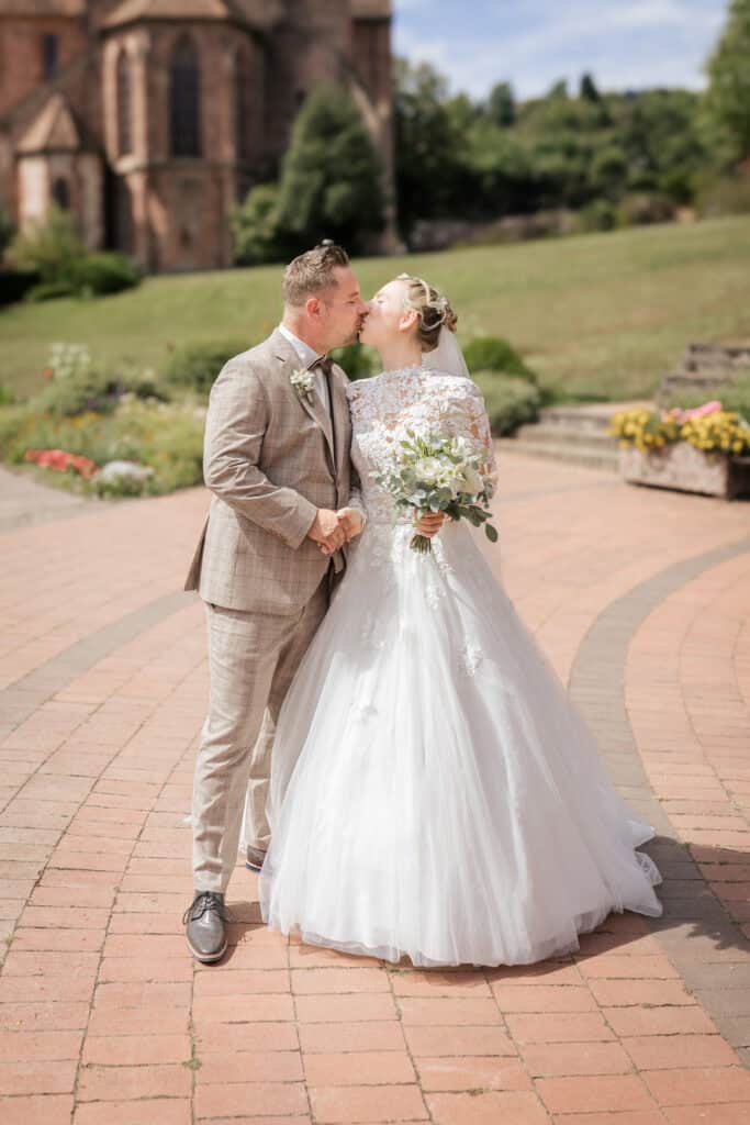 First Look Moment mit Kuss des Brautpaares vor Kirche