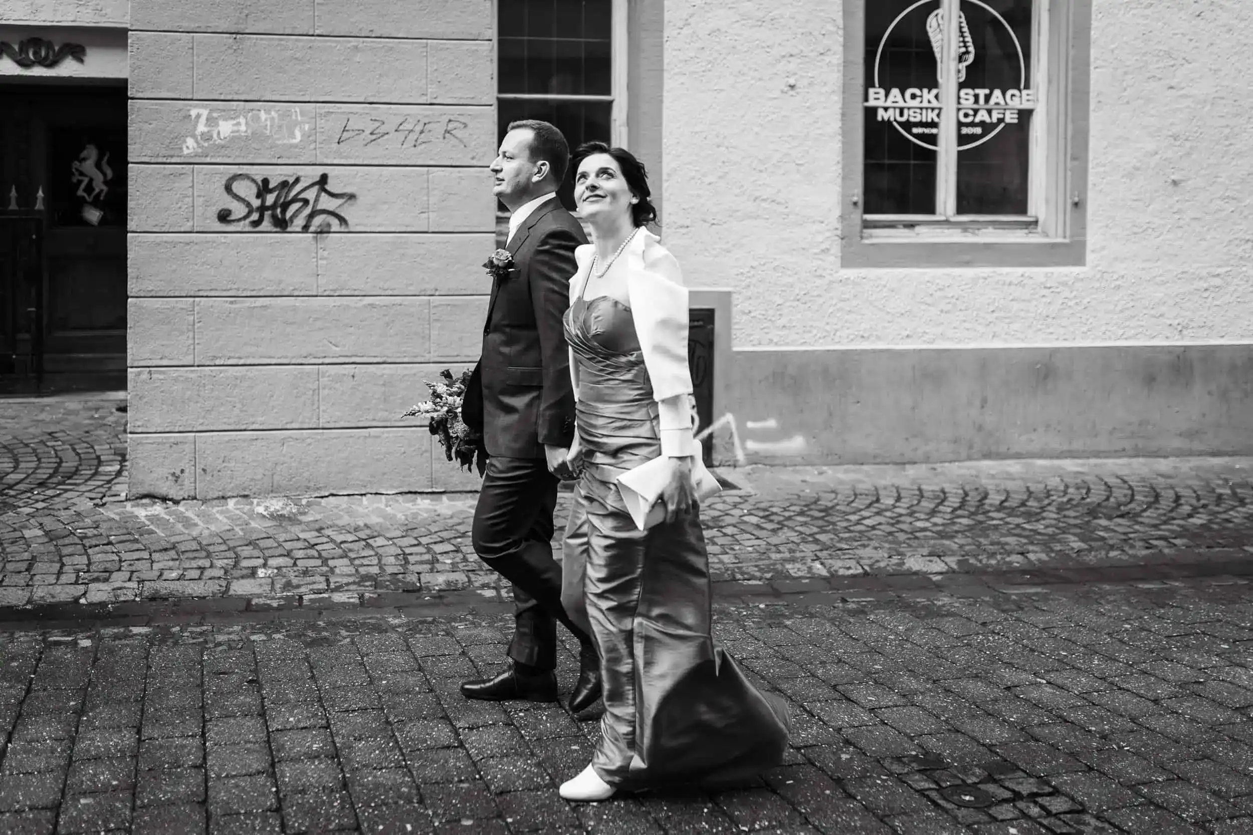 Hochzeitspaar in Abendkleidung läuft durch Altstadt – urbane Reportage in Schwarzweiß