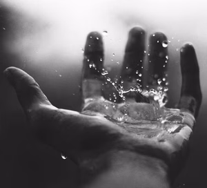 Water dropping into the palm of a hand