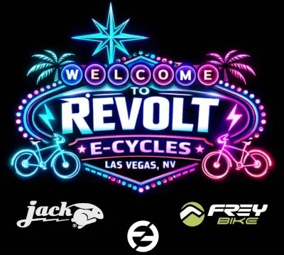 A neon Las Vegas-style sign reading "WELCOME TO REVOLT E-CYCLES LAS VEGAS, NV" with glowing bicycles, palm trees, and partner logos (Jack Rabbit, Frey Bike) below.