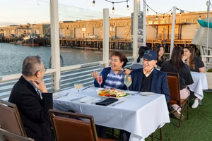 Happy customers on the Bayside patio enjoying cocktails and salad