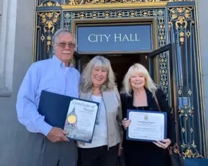 Tom and Cheryl smiling outside of City Hall, celebrating their recent achievement