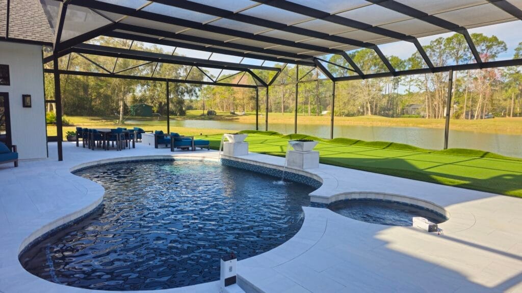 Custom screen enclosures Jacksonville featuring a spacious patio with white frame and mesh screens, surrounded by lush greene