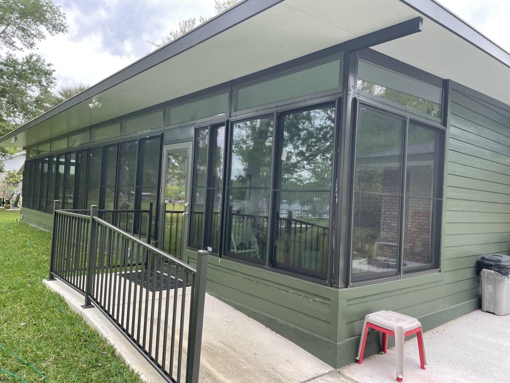 custom sunrooms Jacksonville - Spacious custom sunroom in Jacksonville with large windows, cozy seating, and lush greenery ou