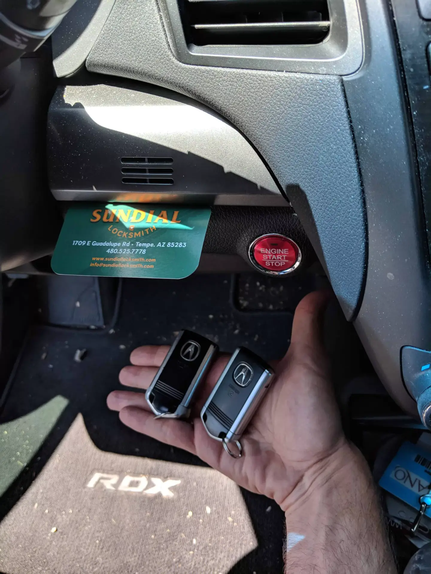 How To Get A New Car Key Made Without The Original A locksmith holds a replacement smart key fob inside an Acura RDX vehicle near the push-button ignition and dashboard.