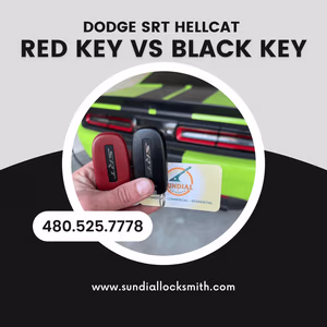 Dodge SRT Hellcat Red Key vs Black Key A hand holding a red key fob and a black key fob for a Dodge SRT Hellcat in front of a green Hellcat vehicle.