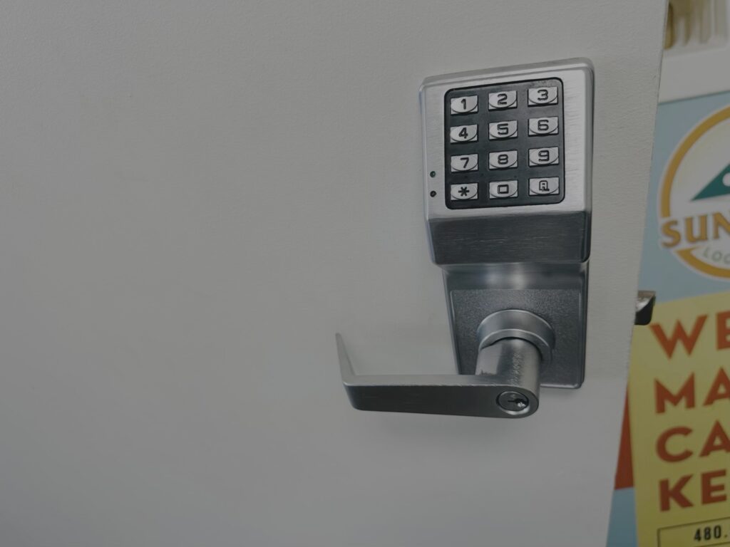 Digital Keypad Door Lock Installation A stainless steel electronic keypad lock with lever handle mounted on a white commercial door.
