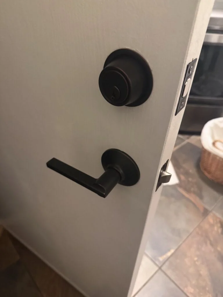 Window Lock Installation: A Small Upgrade with a Big Security Impact A matte black deadbolt and lever door handle set installed on a white interior door.