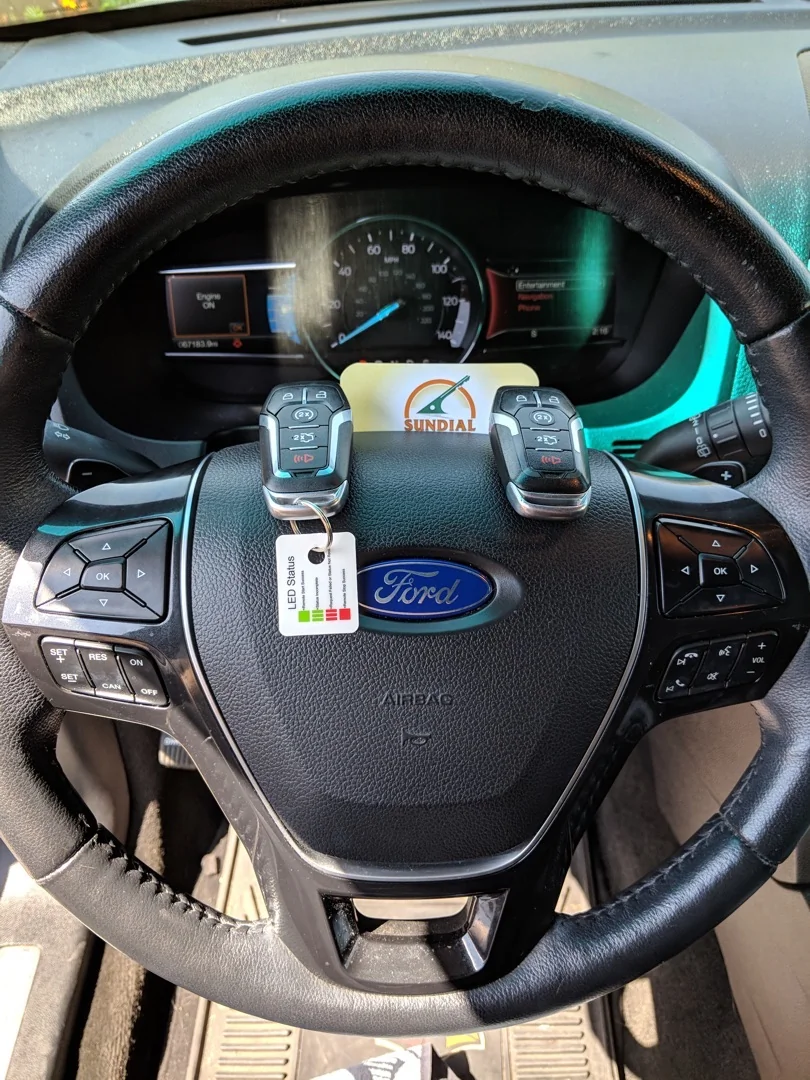 Ford Explorer Key Replacement: What It Costs and How Long It Takes A locksmith for Ford Explorer programming a replacement key fob using professional diagnostic equipment connected to a Ford Explorer in a sunny Arizona parking area