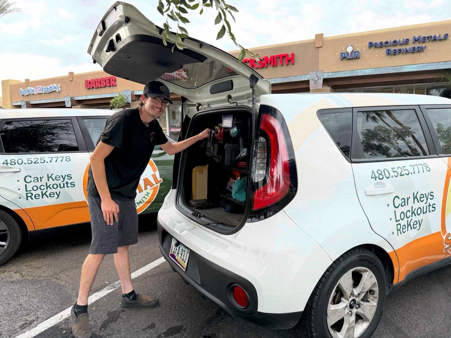 How Often Should You Actually Rekey Your Locks? A locksmith technician stands beside an open hatchback car branded with Car Keys Lockouts ReKey signage in a parking lot.