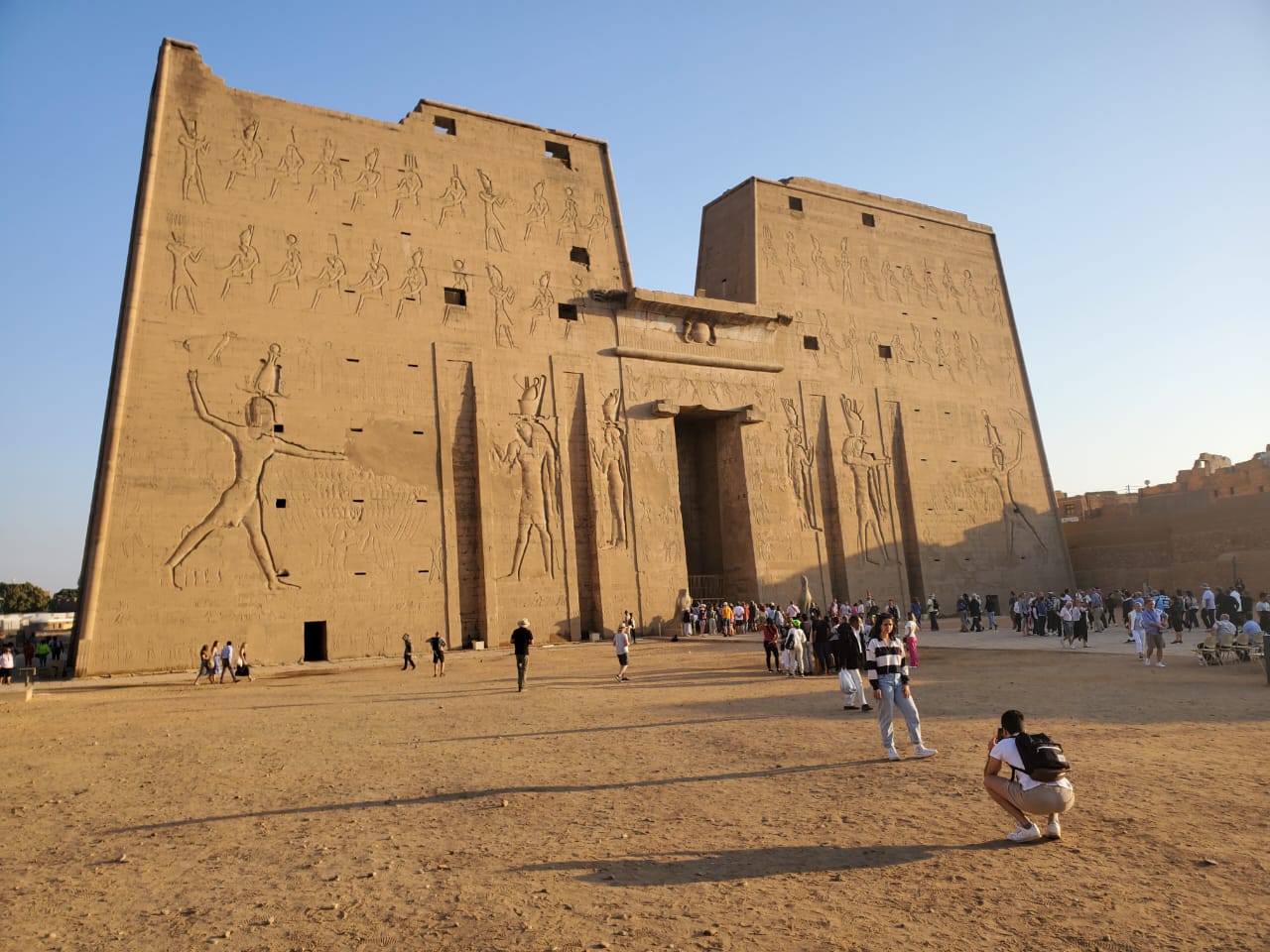 Tourists stroll in front of the majestic Karnak Temple in Egypt, a highlight of group tours and vacation packages.