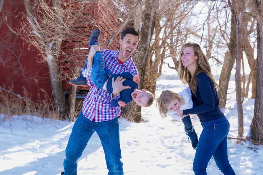 Family enjoying winter outdoors, emphasizing health and wellness at Cannon Pointe Chiropractic. Happy family playing outdoors in the snow, promoting chiropractic care, wellness, and healthy living.