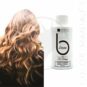 photo d'illustration avec une jeune femme aux cheveux bruns et une mini bouteille de 50 mL de soin après-shampoing pour cheveux bruns de la marque Urban Keratin