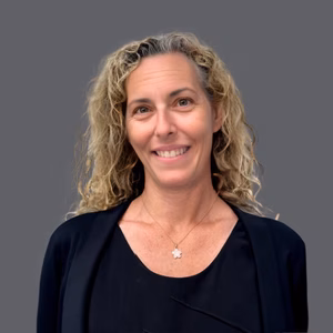 Headshot of Christine Burke, O.D. in professional wear with a grey background.
