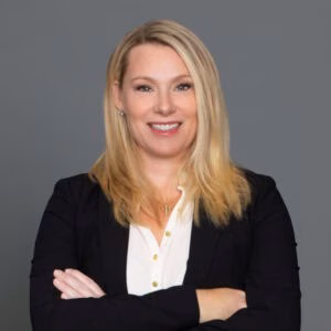Headshot of Dr. Kathryn B. Freidl in professional wear with a grey background.