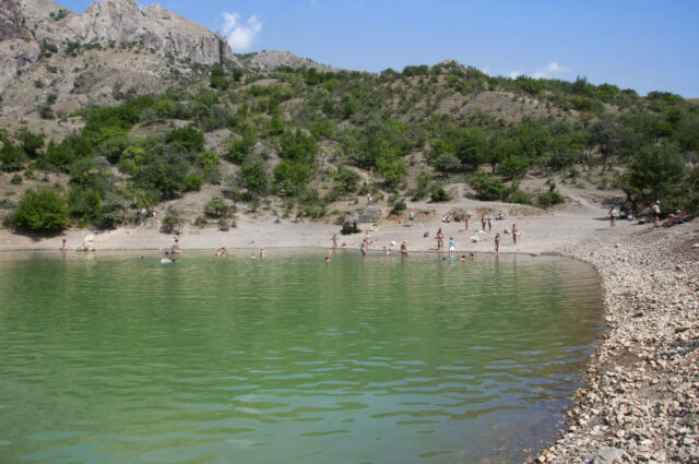 Baignade interdite, eau verte : quand les cyanobactéries menacent vos vacances et votre maisonpeople on a mountain lake on a summer day Baignade interdite, eau verte : quand les cyanobactéries menacent vos vacances et votre maison