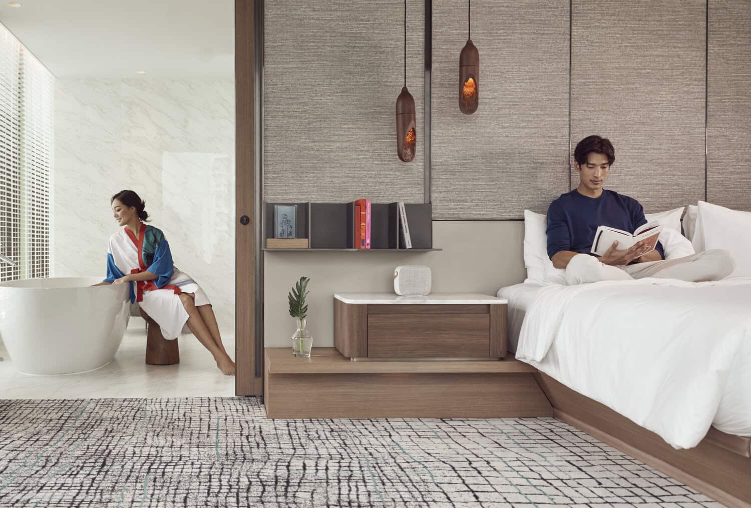 A couple enjoying the view from their room at Kimpton Maa-Lai Bangkok