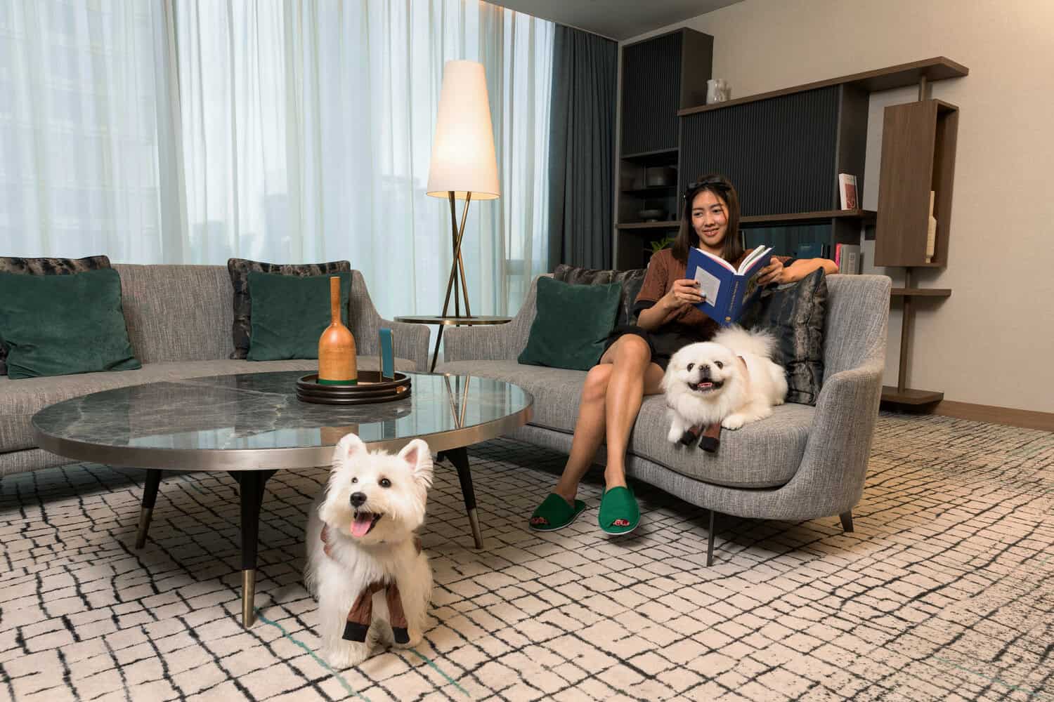 A woman relaxing with her pets at Kimpton Maa-Lai Bangkok, one of the best pet friendly places in Bangkok