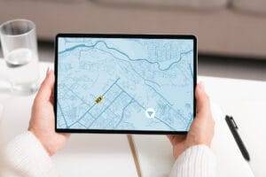 News 24 Woman using a digital tablet to track a taxi on a map, illustrating MapQuest business growth strategies in geolocation servic