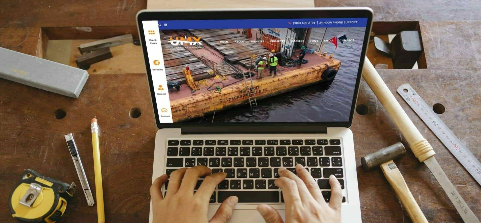 Underwater Mechanix 4 Laptop displaying a commercial diving web design project, showcasing underwater mechanix services with a blue ocean theme.