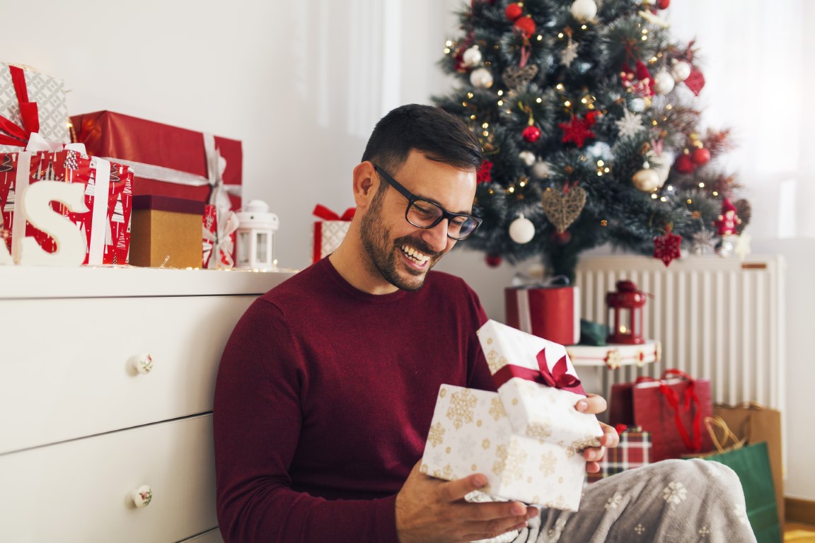 homme qui ouvre son cadeau de noël