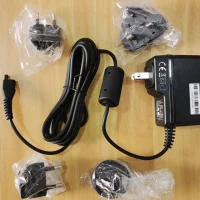 Unboxed Testo 340 charger kit with AC adapter, USB cable, and plug heads arranged on a flat surface