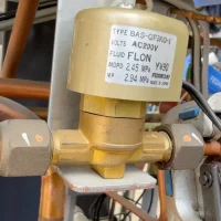 Close-up of FUJIKOKI BAS-QF3KO-1 refrigeration solenoid valve body showing metal surface finish and AC200V coil detail