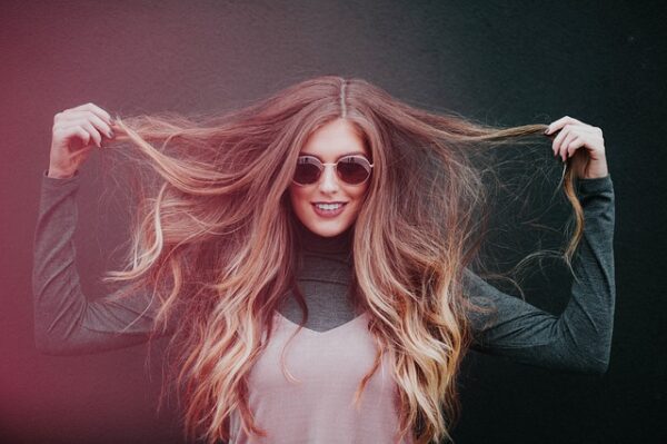 femme-sourire-confiance-cheveux-lunettes de soleil