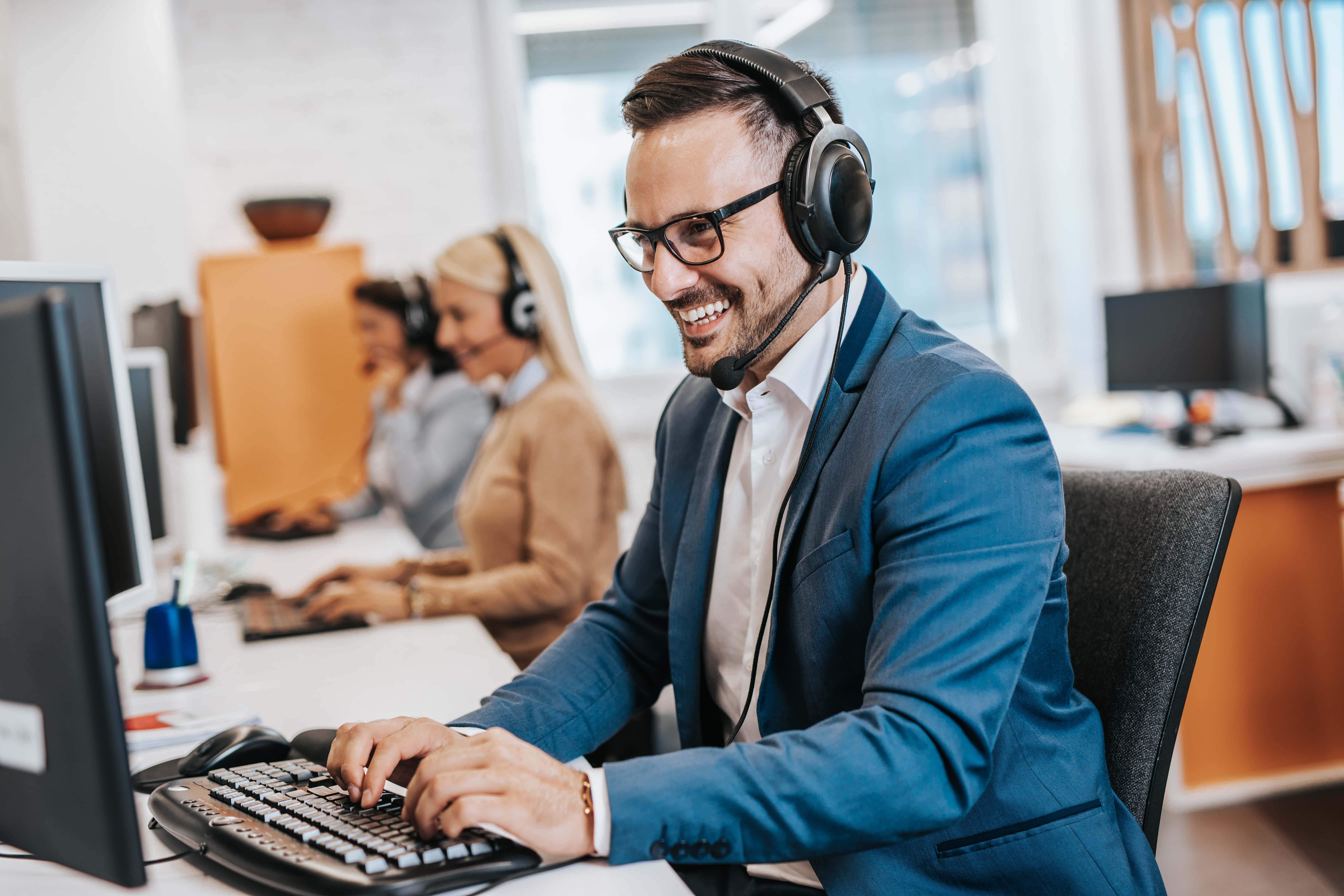 Handsome male customer service agent working in call center office as a telemarketer. Handsome male customer service agent working in call center office as a sales development specialist