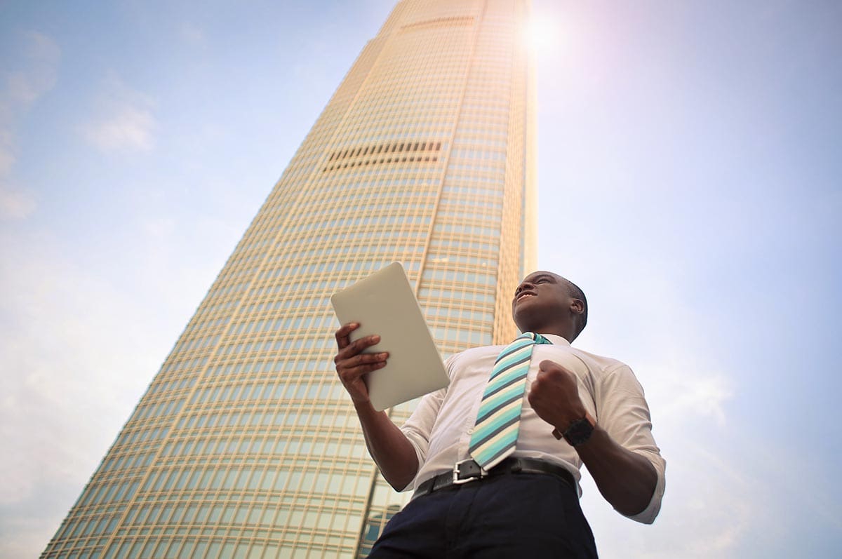 article-image-man-papers Man holding papers in front of a building