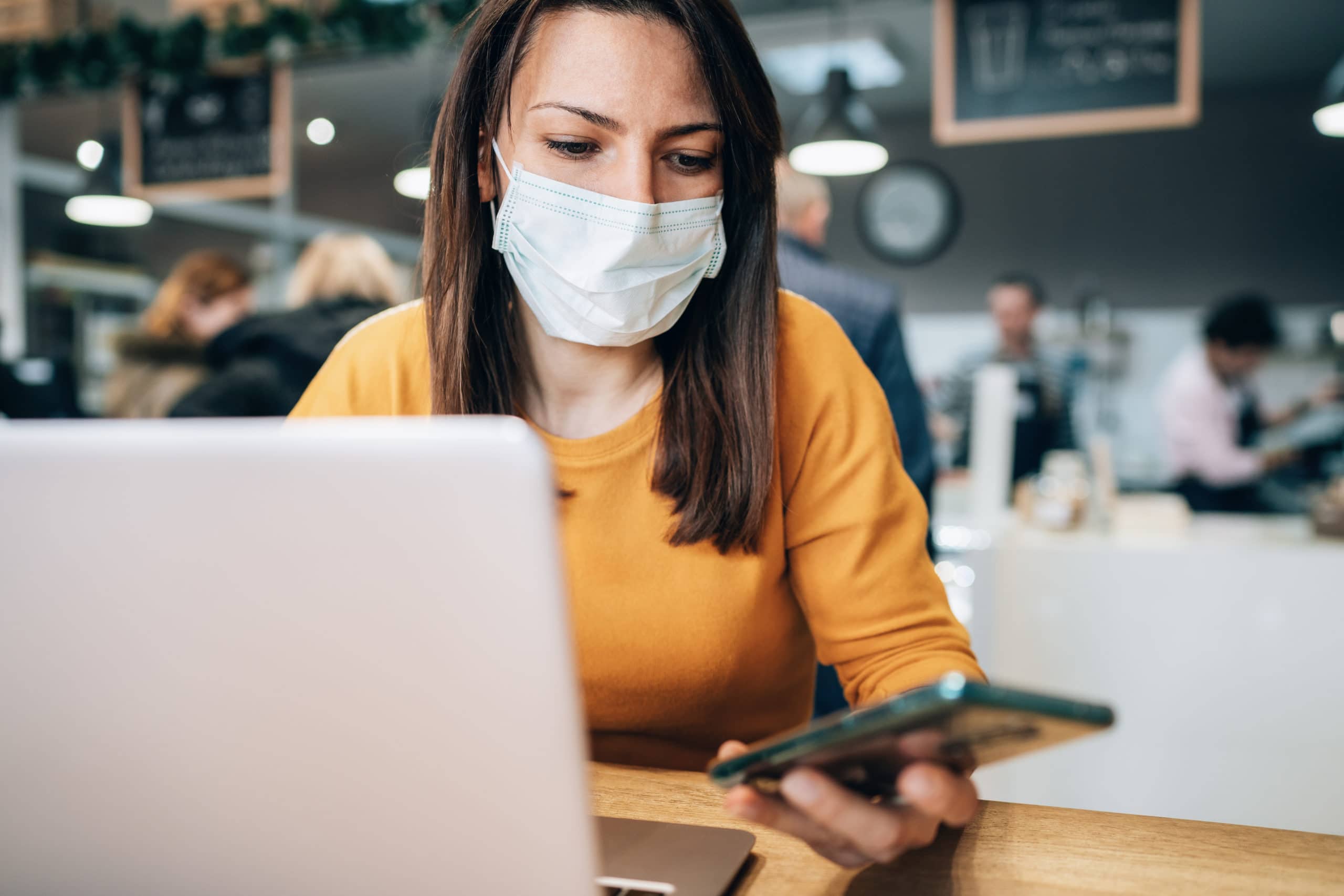 Remote sales call during COVID-19 pandemic Woman with face protective mask calling phone