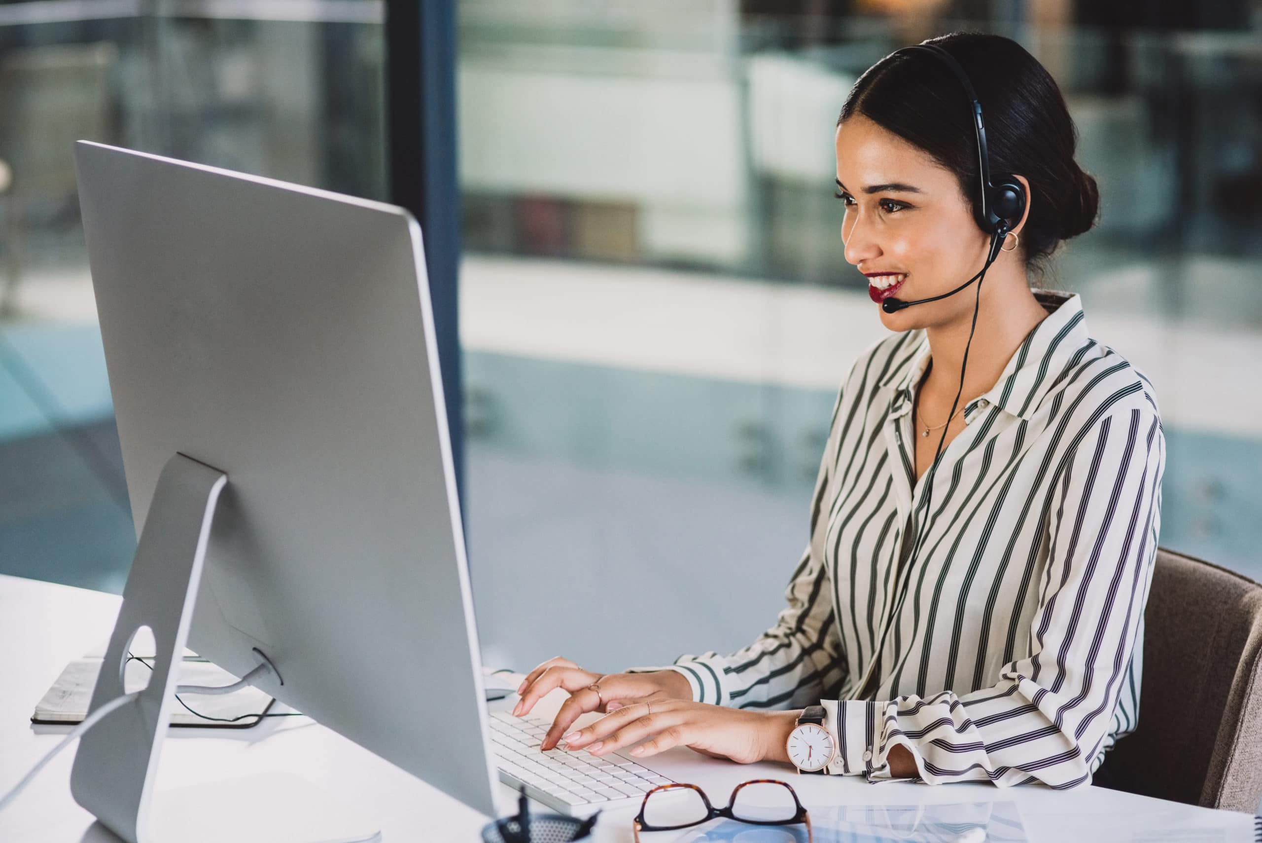 Outbound calling agent with headset working remotely Call center agent on headset and using computer