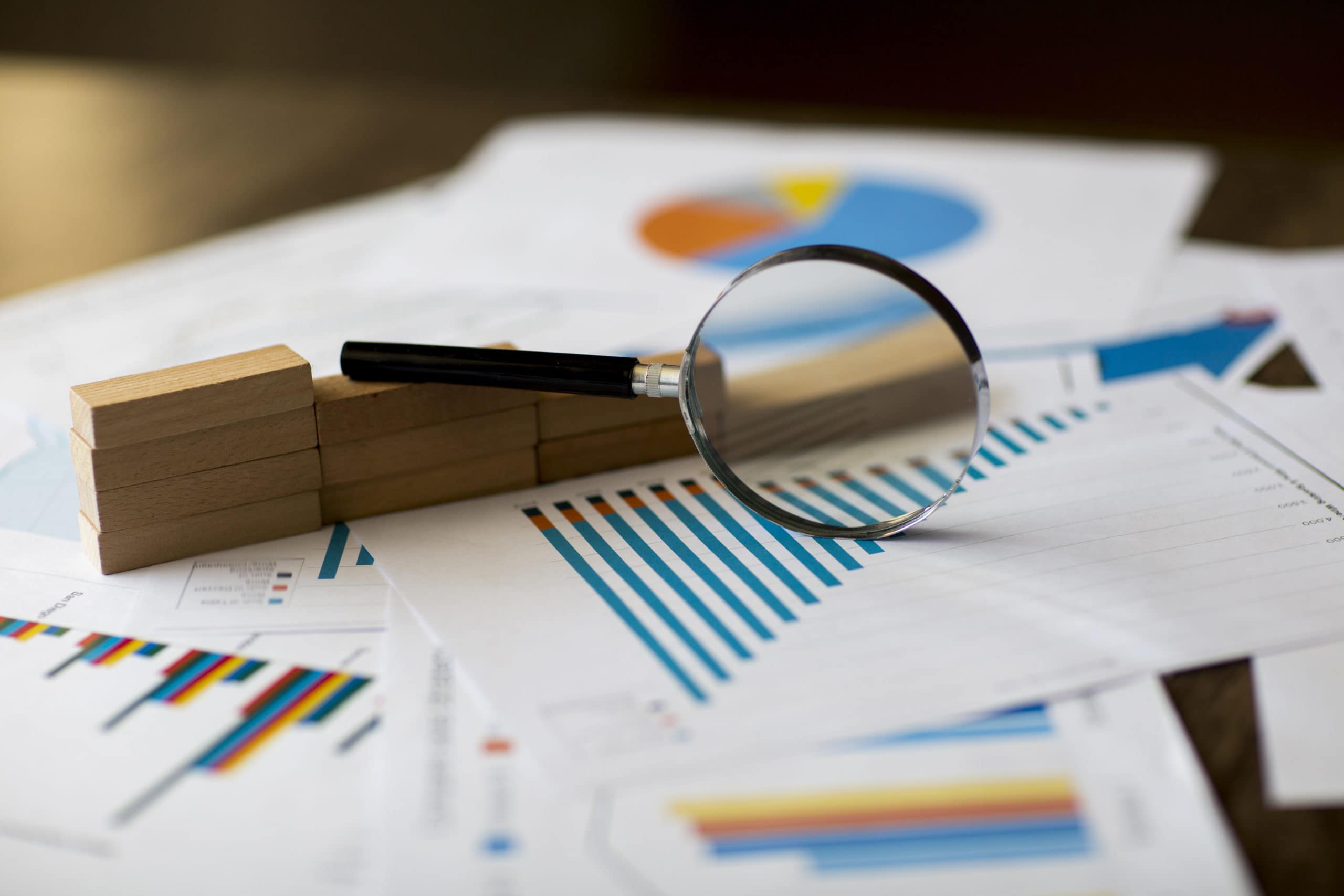 Data Analysis for Sales Performance Business analysis with magnifying glass over sales charts and reports.