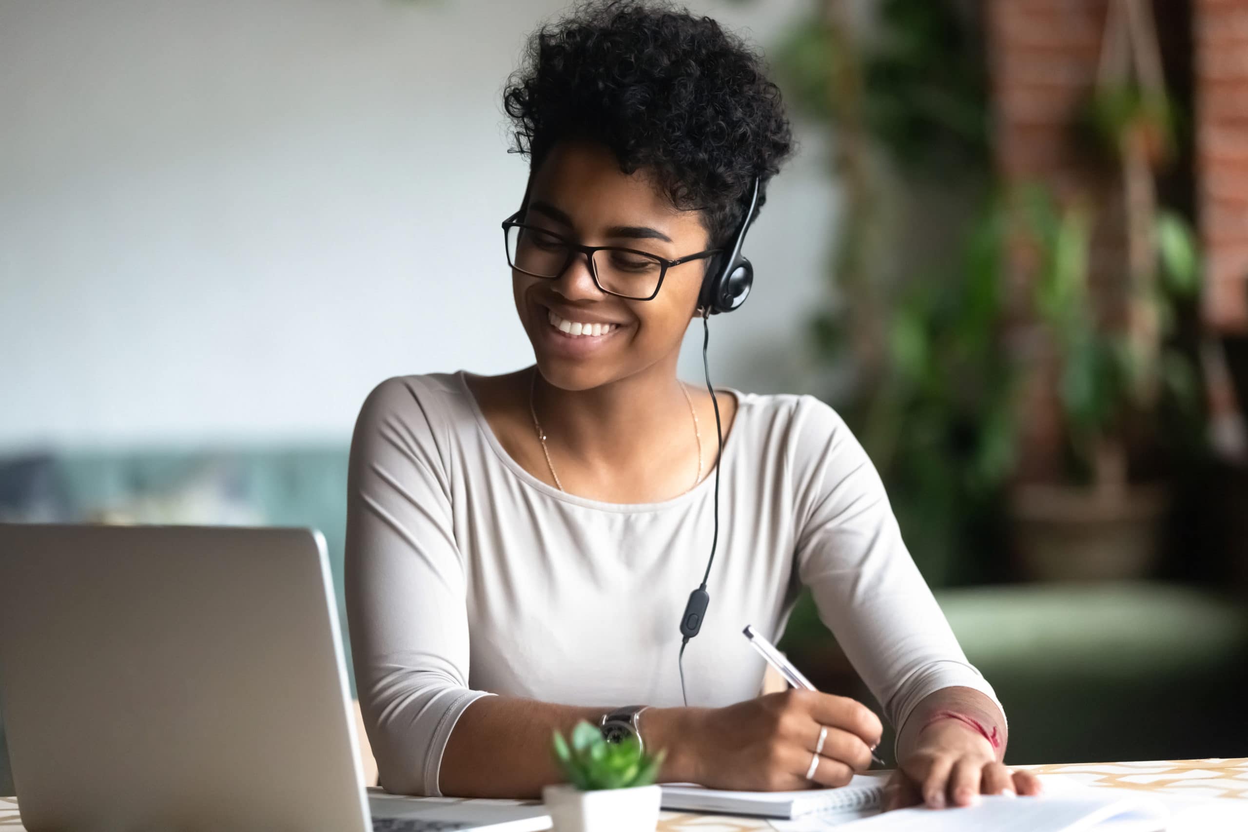 Customer Service Representative with Headset Working at Desk Customer service agent wearing headset, smiling while working at her desk for outbound calling.