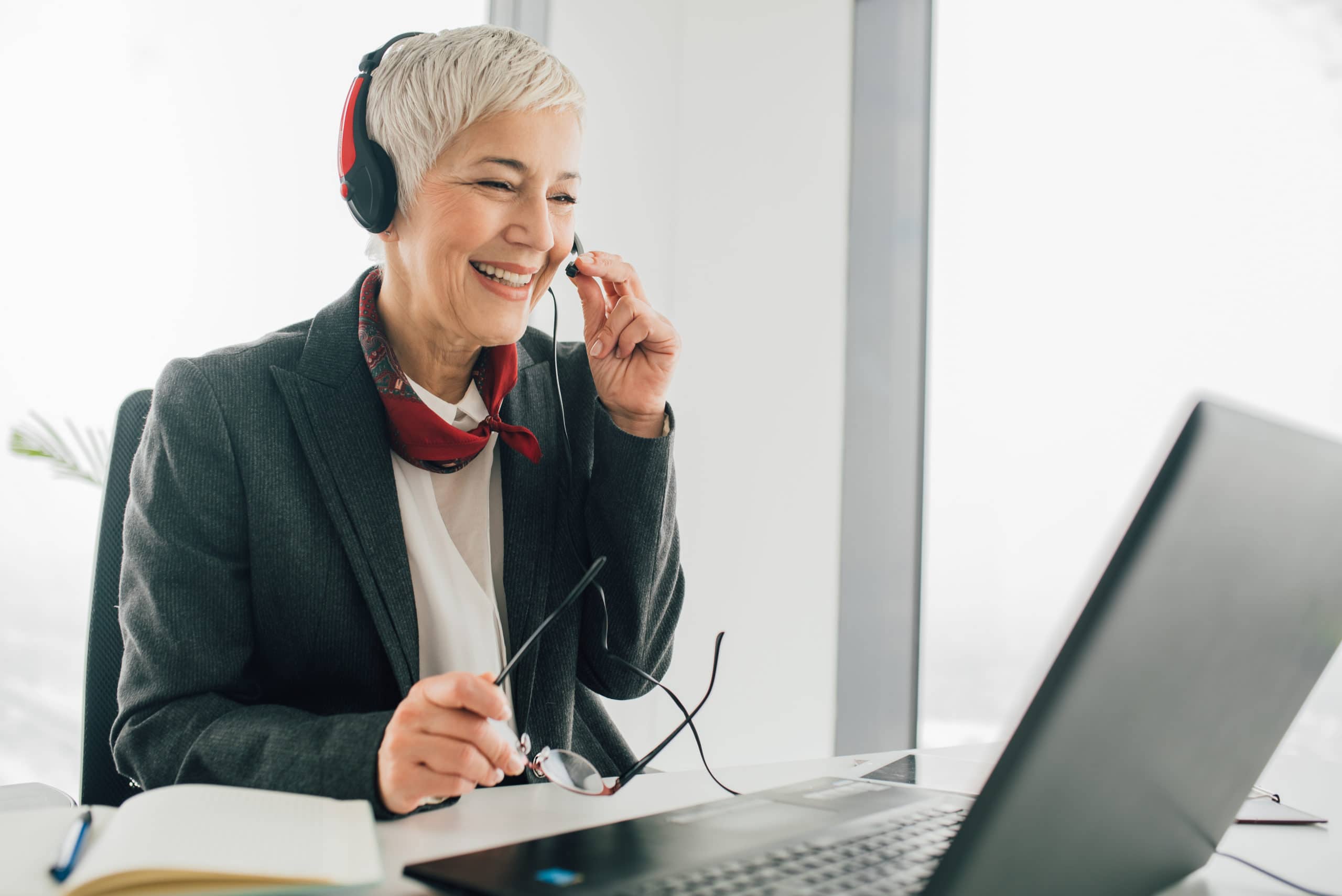 Effective Cold Calling Strategies for Sales Success Smiling woman with headset making a cold call at her desk, improving sales techniques.
